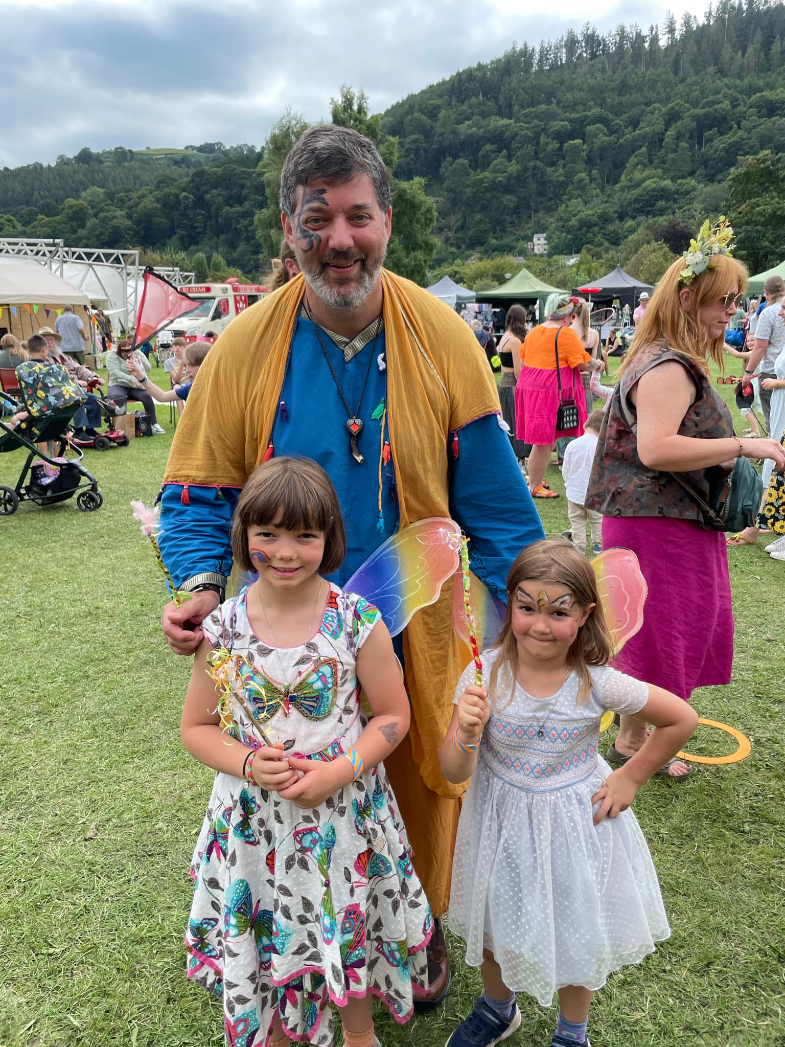 A father and his two daughters at a festival.
