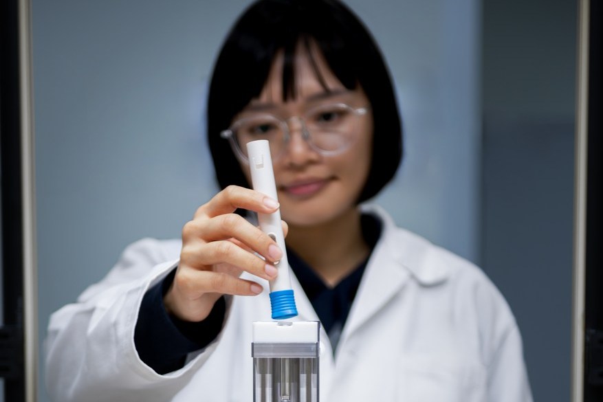 Scientist placing a sample into a laboratory machine.